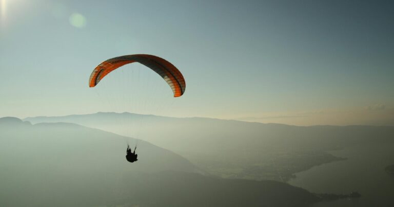 Experience the thrill of paragliding over the stunning Lake Annecy with breathtaking mountain views.